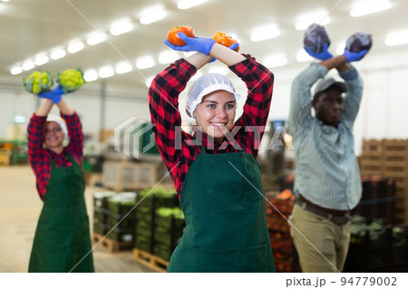 Vegetable warehouse workers preforming dance in workplace Vegetable warehouse workers preforming dance in workplace 94779002