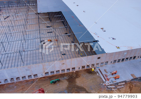 In the construction of a steel warehouse, roof truss frames are installed on industrial buildings In the construction of a steel warehouse, roof truss frames are installed on industrial buildings 94779903