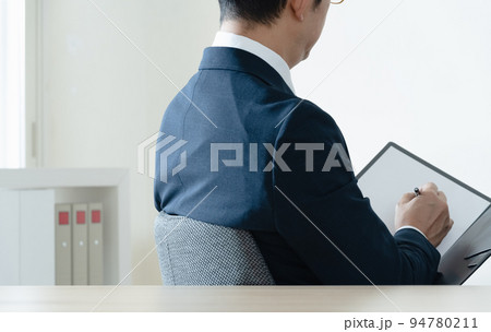 書類を見て悩むビジネスマン 94780211
