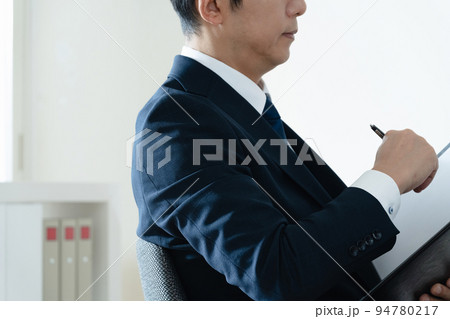 書類を見て悩むビジネスマン 書類を見て悩むビジネスマン 94780217