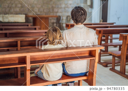 Christian dad tells his son Bible stories about Jesus sitting in kirk. Faith, religious education, modern church, father day, fatherly responsibilities, father influence on formation of son worldview Christian dad tells his son Bible stories about Jesus sitting in kirk. Faith, religious education, modern church, father day, fatherly responsibilities, father influence on formation of son worldview 94780335