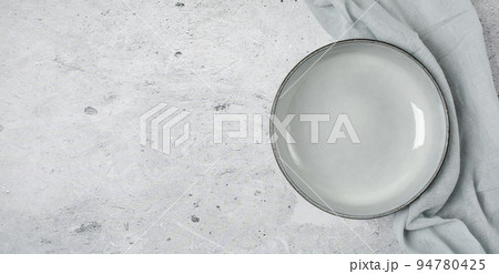 Empty black slate plate on grey stone table and napkin.  94780425