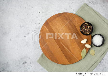 Wooden cutting board and spices, herb for food on black stone table Wooden cutting board and spices, herb for food on black stone table 94780426