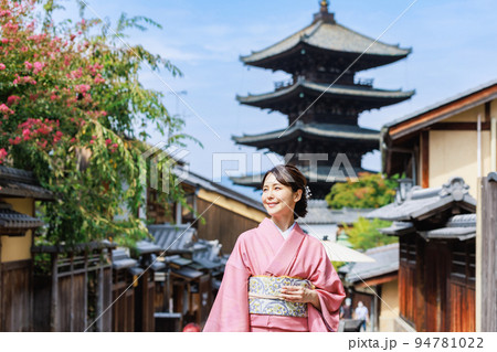 五重塔を背景に立つ着物姿の若い女性 94781022