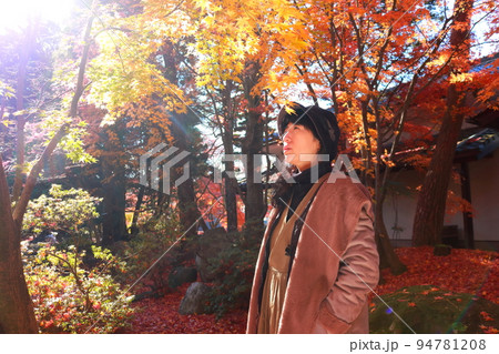 紅葉を見上げる女性 94781208