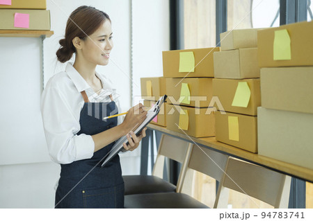 Female entrepreneur checking order preparing for delivery. Female entrepreneur checking order preparing for delivery. 94783741