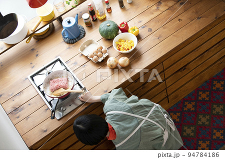 玉ねぎと挽肉を炒める若い女性 94784186