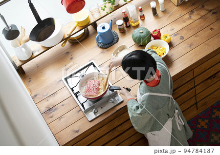 玉ねぎと挽肉を炒める若い女性 玉ねぎと挽肉を炒める若い女性 94784187
