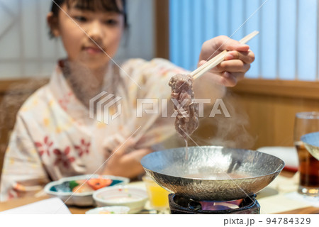 温泉旅行で黒毛和牛のしゃぶしゃぶを食べるアジア人の女性 温泉旅行で黒毛和牛のしゃぶしゃぶを食べるアジア人の女性 94784329