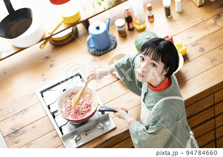 料理をする若い女性 カメラ目線 俯瞰 料理をする若い女性 カメラ目線 俯瞰 94784660