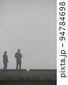 秋の早朝　朝霧の中で魚釣りをするカップル 94784698