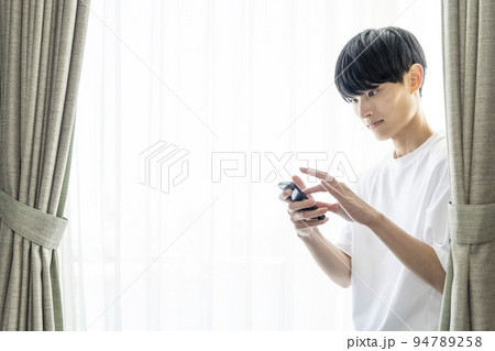 朝のSNS確認をする男性 94789258