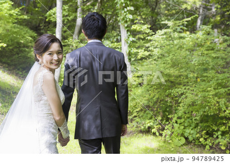 屋外でウェディングをする新郎新婦 屋外でウェディングをする新郎新婦 94789425