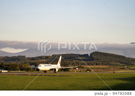 夕暮れの旭川空港　離陸中の飛行機と就実の丘　北海道旭川市（東神楽） 94792088