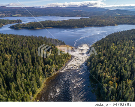 Aerial view famous waterfall Tannforsen northern Sweden, with a rainbow in the mist and rapid flowing cascades of water Aerial view famous waterfall Tannforsen northern Sweden, with a rainbow in the mist and rapid flowing cascades of water 94792395