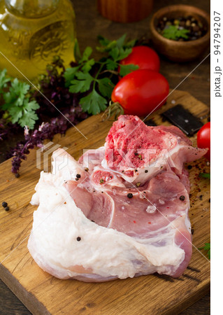 Fresh raw meat. Raw pork meat steak with olive oil, tomatoes and herbs on wooden table. Copy space. Fresh raw meat. Raw pork meat steak with olive oil, tomatoes and herbs on wooden table. Copy space. 94794207