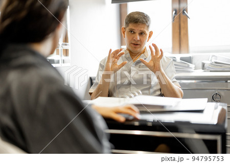 Woman in a bathrobe on appointment with senior therapist 94795753
