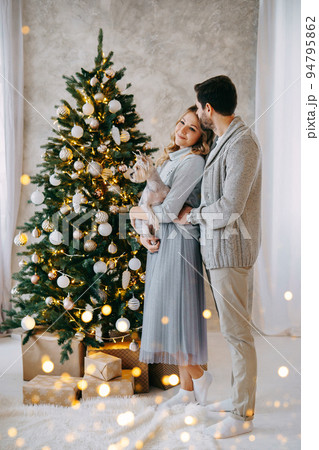 A happy couple in love - a man and a woman. A family in a bright New Year's interior with a Christmas tree 94795862