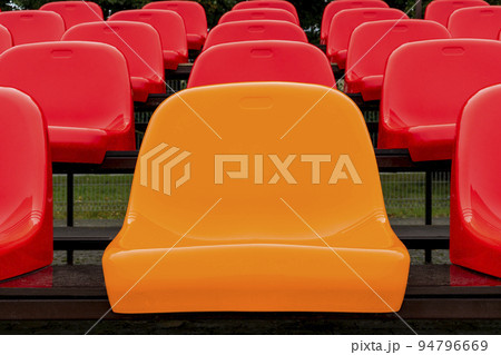 One yellow seat and rows of red ones, as indviduality concept 94796669