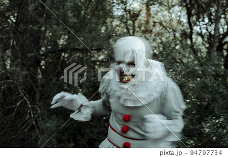 creepy evil clown in motion the woods at dusk 94797734