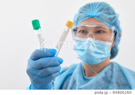 Female scientist holding two test tubes in laboratory doing research and analysis. Healthcare and medicine concept Female scientist holding two test tubes in laboratory doing research and analysis. Healthcare and medicine concept 94800260