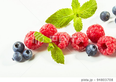 Raspberries and blueberries on white background 94803708