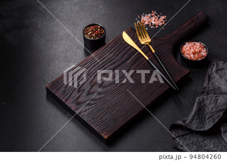 Empty black plate over dark stone background with free space. Top view 94804260