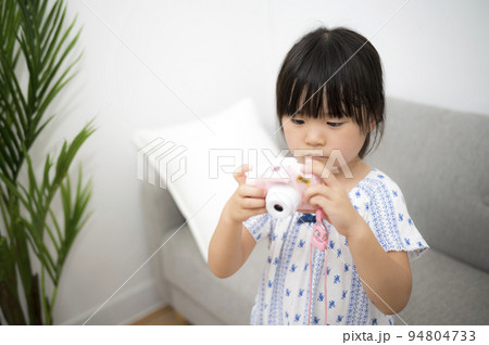 自宅の部屋でおもちゃのカメラを撮って遊ぶ女の子 自宅の部屋でおもちゃのカメラを撮って遊ぶ女の子 94804733