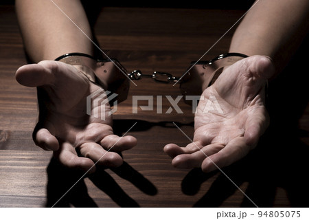 手錠をかけられた男性の手 94805075