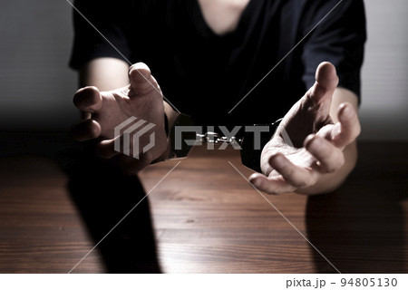 手錠をかけられた男性の手 94805130