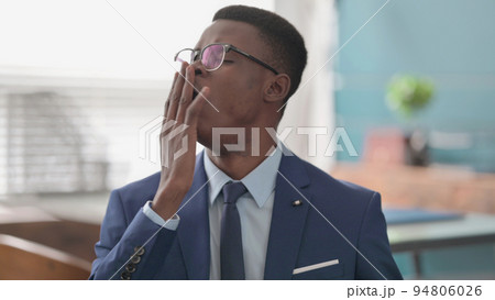 Sleepy Young African Businessman Yawning Sleepy Young African Businessman Yawning 94806026