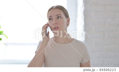 Displeased Woman Talking Angrily on Smartphone 94806223