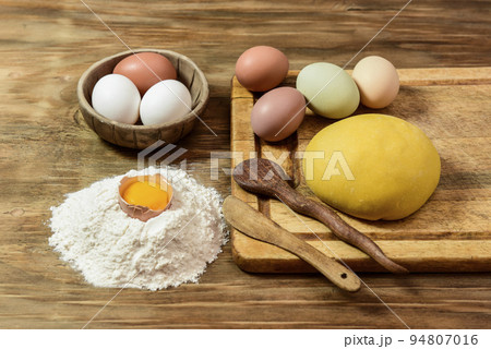 Egg noodle dough bun, with ingredients on the table. 94807016