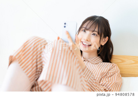 ベッドでスマホを使う若い女性 ベッドでスマホを使う若い女性 94808578