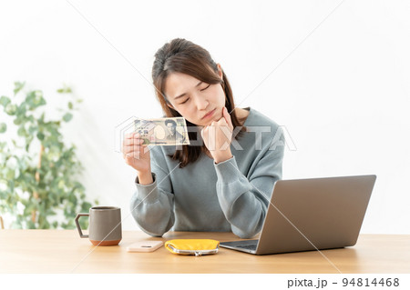 千円札を持つ悩む女性 千円札を持つ悩む女性 94814468