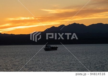 夕焼けに染まる海 94814516