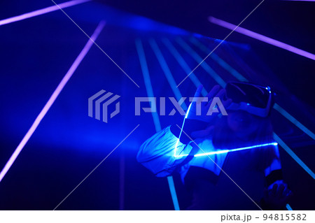 Woman is using virtual reality headset to access in metaverse. 94815582