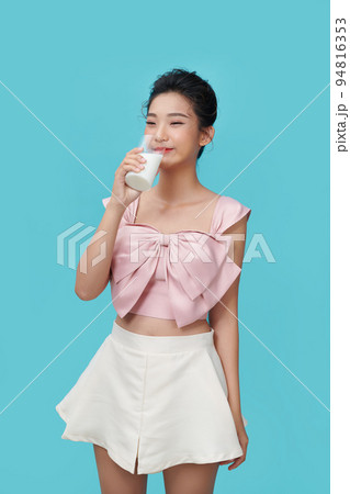Beautiful young woman drinking milk on blue background 94816353