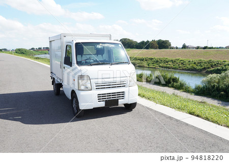 土手沿いの道路を走る軽貨物 94818220