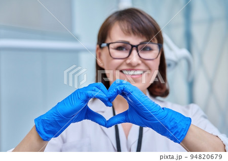 Female doctor dentist in a face mask in a dental office Female doctor dentist in a face mask in a dental office 94820679