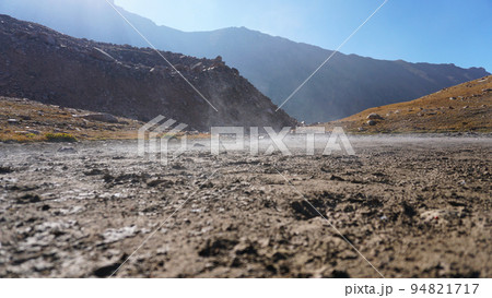 Steam rises from the ground in the mountains. 94821717