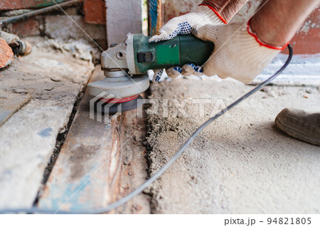 a man in gloves cleans the metal structure from rust.  94821805