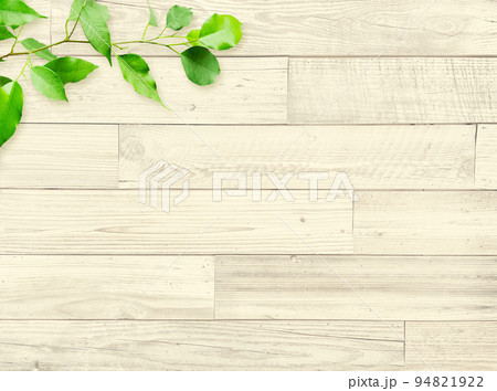 ペールイエローの木目の粗い製材の古びた板壁に緑の葉が飾られた背景画像1 94821922