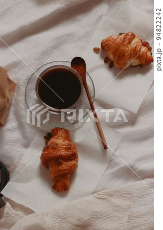 Vertical overhead shot of freshly baked croissants and black coffee for a simple french breakfast 94822242