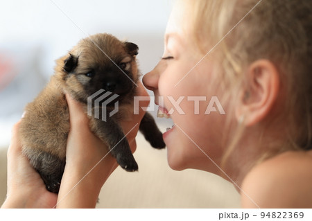 Puppies as a gift in good hands. girl rejoices at a newborn puppy from a shelter Puppies as a gift in good hands. girl rejoices at a newborn puppy from a shelter 94822369