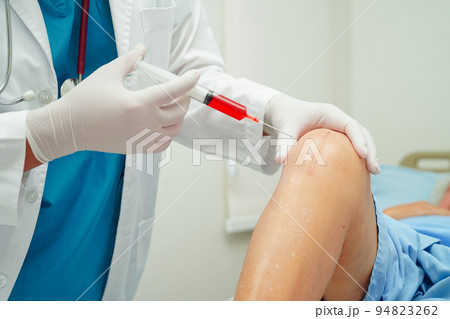 Asian doctor inject Hyaluronic acid platelet rich plasma into the knee of senior woman to walk without pain. 94823262