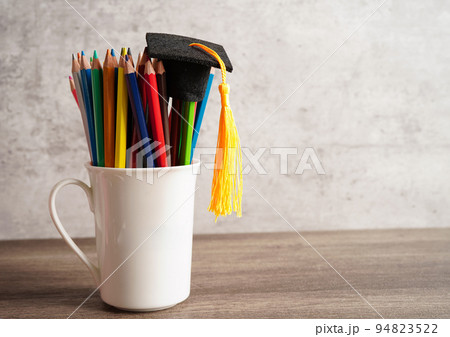 Graduation hat with colorful pencils on book with copy space, learning university education concept. Graduation hat with colorful pencils on book with copy space, learning university education concept. 94823522