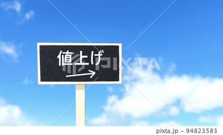 値上げの文字入り黒いプレート_青空背景_右空間 94823583