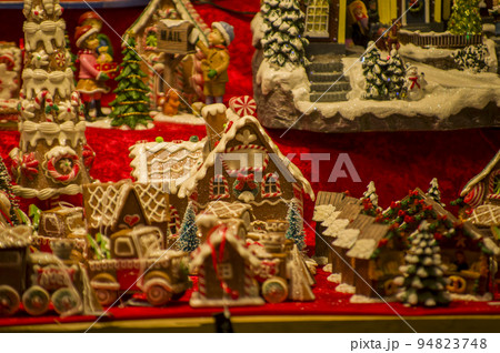 Advent Bazaar Stalls with glass, wooden, ceramic christmas souvenirs in shops. Close up of festive decorations for tree in winter street night market during new year's holiday. Illuminated fair kiosk 94823748
