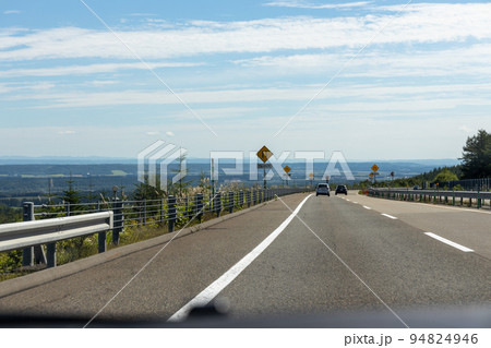 北海道の道路を運転している自動車からの景色 94824946